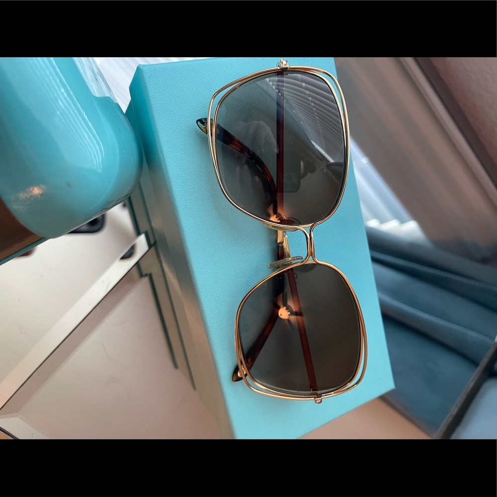 Gold Tiffany & Co sunglasses with small gold stone details on sides.